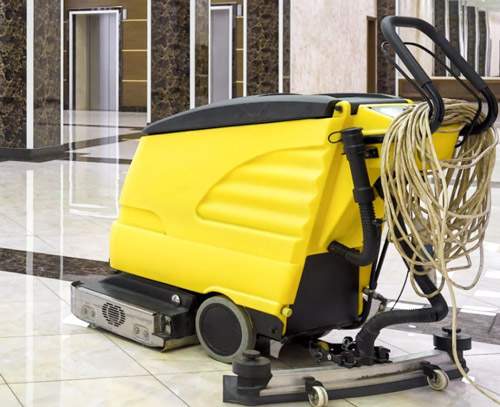Yellow commercial floor scrubber cleaning a facility